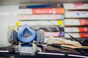 Respirator and gloves with books in background