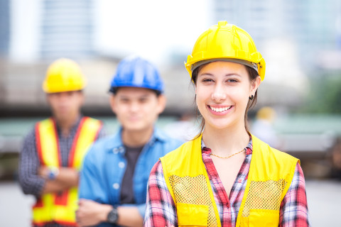 Smiling-Industry-workers-in-hardhats_AdobeStock_214823255