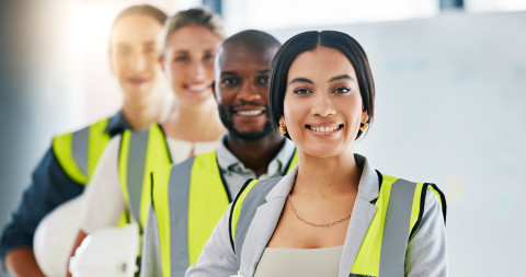 Smiling-Group-vests-and-hart-hats_AdobeStock_528821184